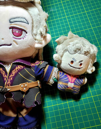 Picture showing the 10cm Astarion plushie holding hands with a 20cm tall Astarion plushies